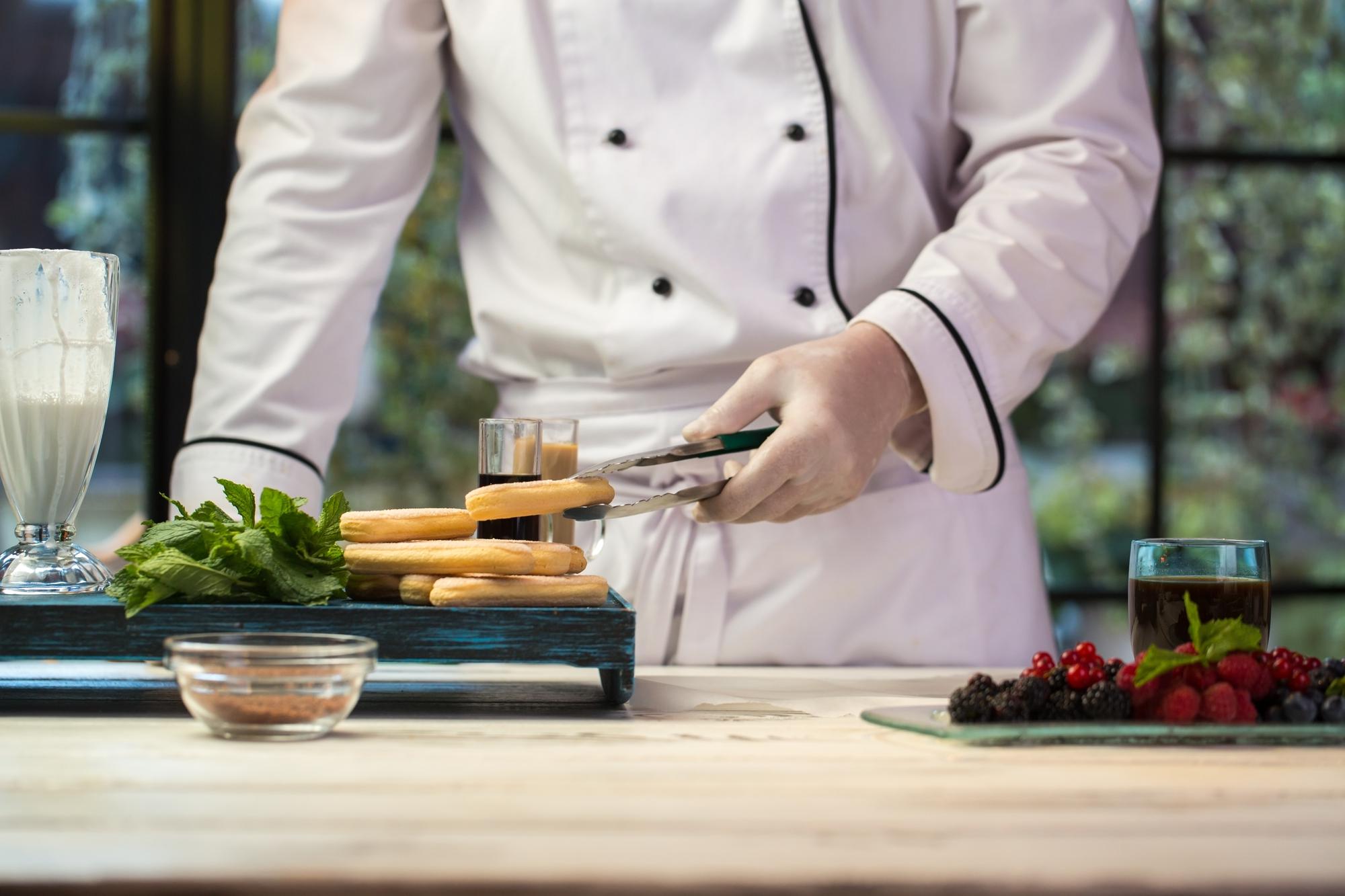 Chef che prepara una composizione di ingredienti in cucina moderna